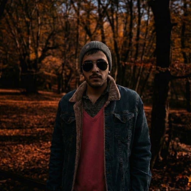 Mahdi in the woods in sunglasses and a beanie, main character energy